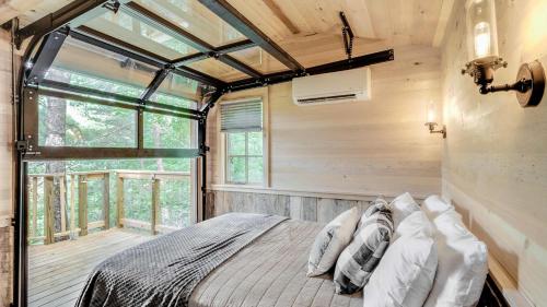 a bedroom in a tree house with a bed at The Blackjack Oak in Treehouse Grove at Norton Creek in Gatlinburg