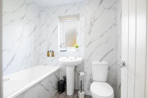 a white bathroom with a toilet and a sink at Stylish Stirling home with stunning views in Stirling