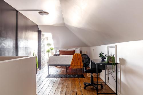 een slaapkamer met een bed en een bureau bij Jungle House Columbus Downtown Free Parking Sleeps 8 - Near Convention Center & Nationwide Arena - 2BR Luxury Home - Pet Friendly Over 5,800 Five Star Stays in Columbus