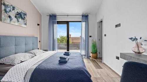 a bedroom with a bed and a large window at Villa Kali in Krnica