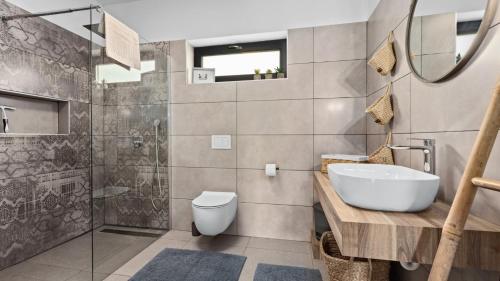 a bathroom with a sink and a toilet and a shower at Villa Kali in Krnica