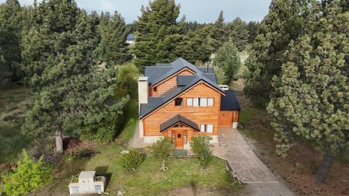 an overhead view of a wooden house in the woods at Casa en Bosque de Pinos in San Carlos de Bariloche