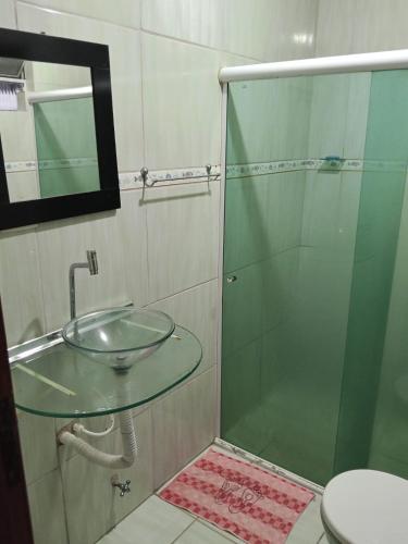 a bathroom with a glass sink and a shower at Casa Japaratinga in Japaratinga