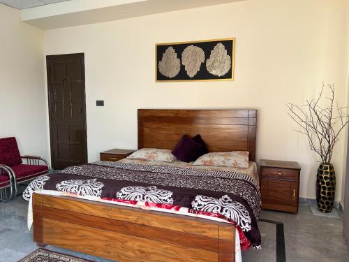 a bedroom with a bed with a wooden headboard at Elysium Inn in Abbottabad