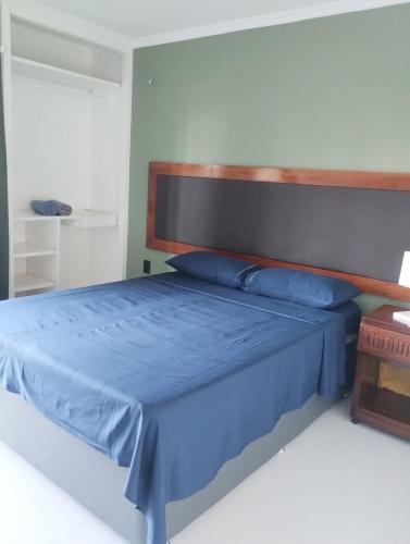 a bedroom with a blue bed with a wooden headboard at Eco Paradise 227 in Cumbuco