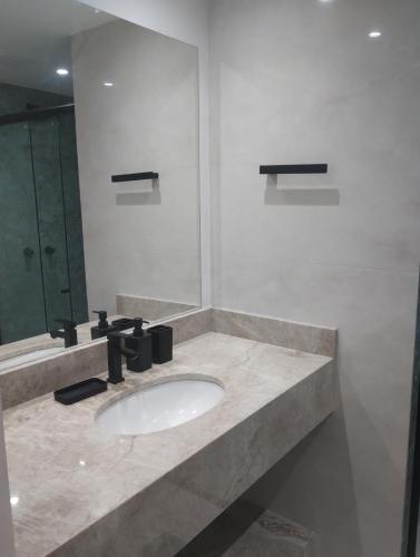 a bathroom with a sink and a mirror at Eco Paradise 227 in Cumbuco