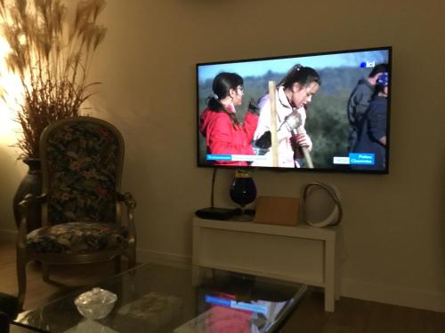 a living room with a flat screen tv on a wall at Chez David Tony in La Celle-sous-Gouzon