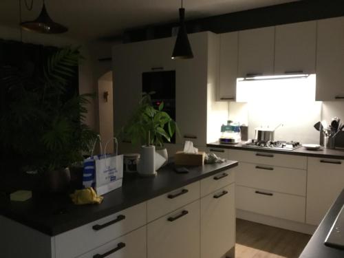 a kitchen with white cabinets and a black counter top at Chez David Tony in La Celle-sous-Gouzon