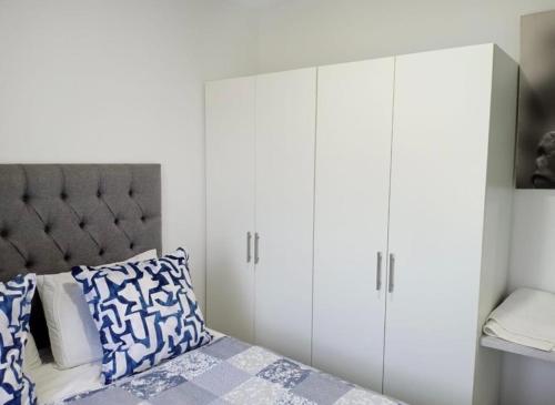 a bedroom with white cabinets and a bed at Bee Bee Adventures in Ballito