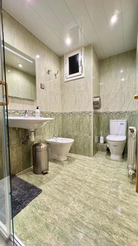 a bathroom with a sink and a tub and a toilet at Pensión Laforja in Barcelona