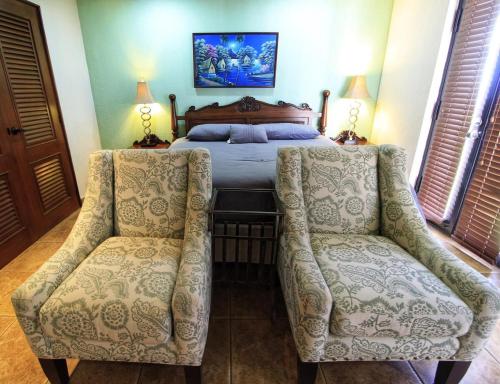 a bedroom with a bed and two chairs at Suite Esteli 114 Gran Pacifica Resort in San Diego