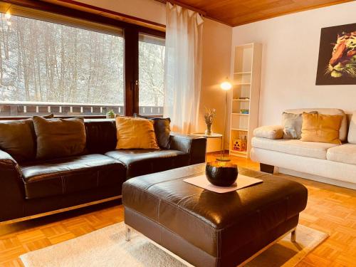 a living room with leather furniture and a large window at Odw homes - Wohnung im Landhaus mit Garten in Trösel