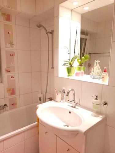 a bathroom with a sink and a mirror and a tub at Chambre double privée in Martigny-Ville