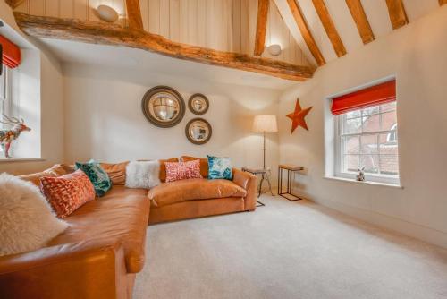 een woonkamer met een bruine bank en een raam bij 2 Bed in Little Walsingham oc-2237 in Little Walsingham