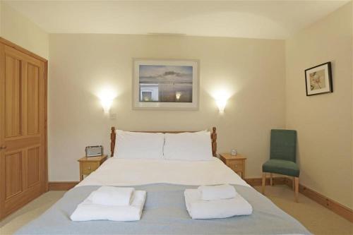a bedroom with a bed with two towels on it at 2 Bed in Southwold oc-weh in Southwold