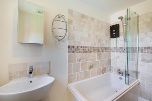 a bathroom with a tub and a sink and a shower at 2 Bed in Heacham oc-2013 in Heacham