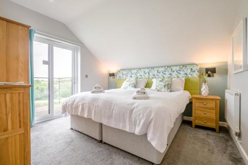 a bedroom with a large white bed and a window at 6 Bed in Winnards Perch oc-t29966 in Saint Columb Major