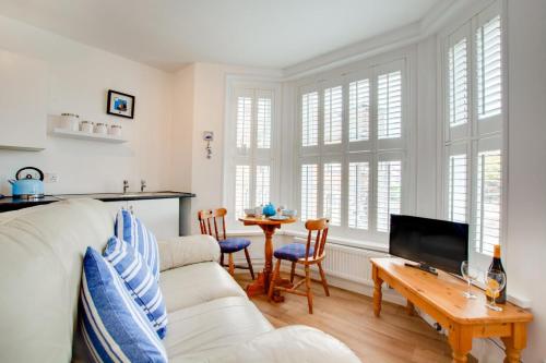 a living room with a white couch and a table at 1 Bed in Sheringham oc-2033 in Sheringham