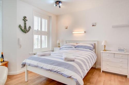 a white bedroom with a bed and a window at 1 Bed in Sheringham oc-2033 in Sheringham