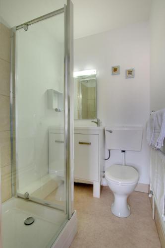 a bathroom with a toilet and a glass shower at 1 Bed in Sheringham oc-2033 in Sheringham
