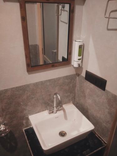 a white sink in a bathroom with a mirror at Hill Side Heaven Homestay in Nainital