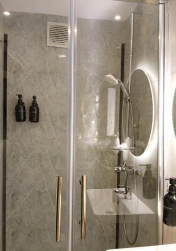 a shower with a glass door in a bathroom at Midnight Crown Suite in Hannover