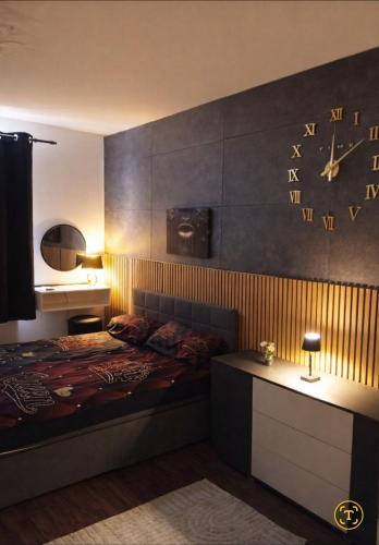 a bedroom with a bed with a clock on the wall at Midnight Crown Suite in Hannover
