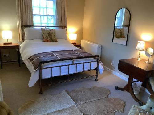a bedroom with a bed and a table and a mirror at The Somerton Hideaway in Somerton