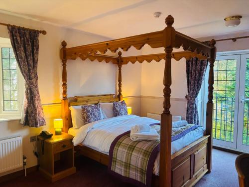 a bedroom with a canopy bed in a room at Little Silver Country Hotel in Tenterden