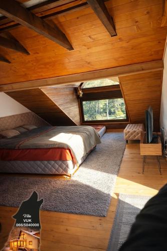 a bedroom with a bed and a large window at Villa WOLF in Divčibare