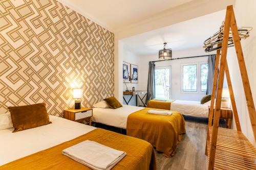 a room with three beds and a wall mural at Carregado First Floor in Carregado