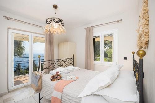 a bedroom with a bed with a view of the ocean at Villa Nefeli in Apergátika