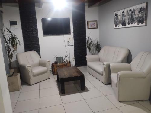 a living room with two chairs and a tv at Departamentos Mama carmen in Mina Clavero