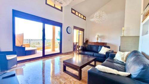 a living room with a blue couch and a table at Luna-Villa de Riviera with Sea-View in Mijas Costa
