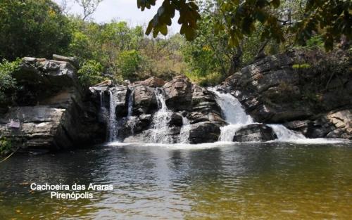 a waterfall in the middle of a pool of water at Pousada Renascer Park in Pirenópolis