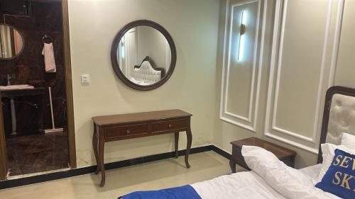 a bathroom with a mirror and a bed and a table at Seven Sky Hotel in Murree