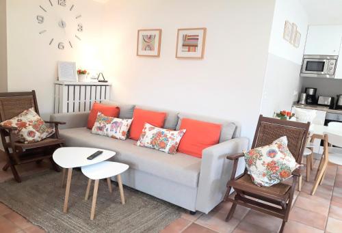 ein Wohnzimmer mit einer Couch und Stühlen und einer Uhr in der Unterkunft alaia apartamento in Zarautz