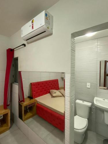 a small bedroom with a red bed and a toilet at Fênix 2 in São Paulo