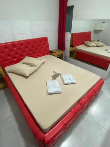 a red bed in a room with two towels on it at Fênix 2 in São Paulo