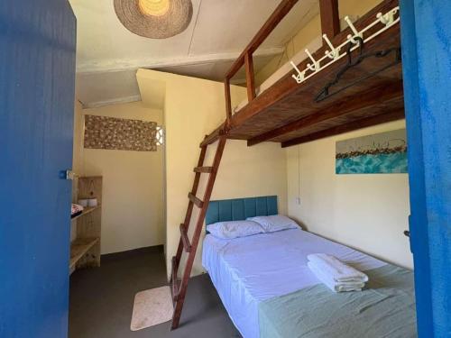 a bedroom with two bunk beds and a ladder at Pura Vida Hostel e Pousada - Boipeba in Ilha de Boipeba