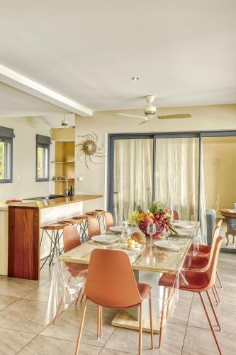 a dining room and kitchen with a table and chairs at Comme un bateau sur l'océan in Saint-Leu