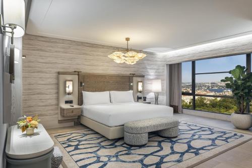 a bedroom with a white bed and a large window at Hilton Istanbul Bosphorus in Istanbul