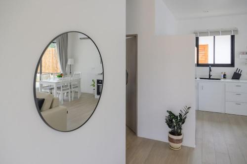 a living room with a mirror and a kitchen at Zen Beach Lake Villa 3 - orchid villa in Haad Chao Phao