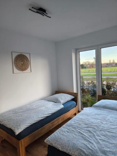 two beds in a room with a window at SeeZeitApartments Whg 4 in Lembruch
