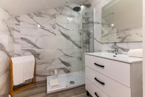 a bathroom with a white sink and a shower at Carregado Second Floor in Carregado