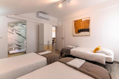 a room with three beds and a painting on the wall at Carregado Second Floor in Carregado