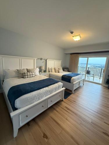two beds in a bedroom with a balcony at Fairway to Heaven at Four Season 2BED2BATH Condo in Lake Ozark