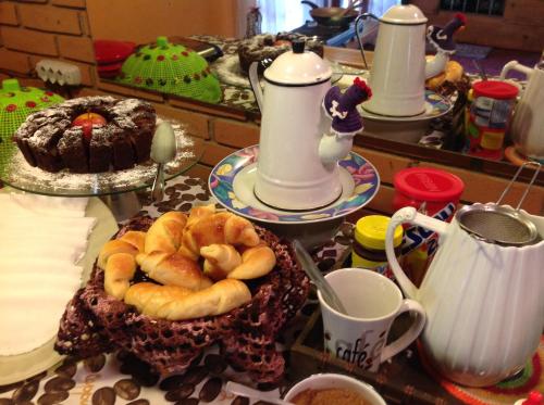 a table topped with plates of pastries and cups of coffee at Pousada Vale Monte Azul in Santo Antônio do Pinhal