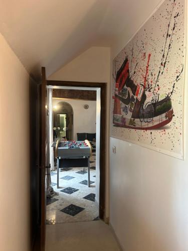un couloir menant à un salon avec un tableau au mur dans l'établissement Gîte la plotuère, à Gy-en-Sologne