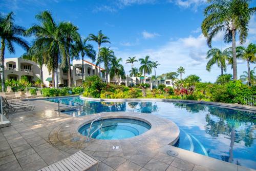 a swimming pool at a resort with palm trees at Palms at Wailea in Wailea